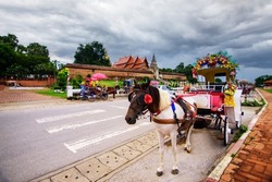 Ancient horse carriage waiting for tourists at Wat Phra That Lampang Luang, Lampang Province, Lampang, Thailand