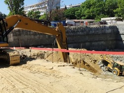 construction site, excavators are digging a foundation pit for a large building close-up