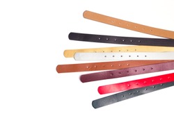 Leather colored belts on a white background top view. There is free space for your inscription.