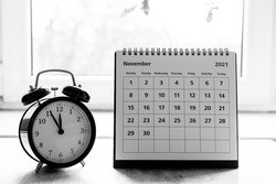 November 2021 grayscale calendar - month page showing date on wooden table