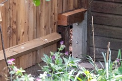 A wildlife highway in an urban garden in London UK. The gap in the wooden fence is large enough to let wildlife, including hedgehogs and badgers, roam freely from garden to garden. 
