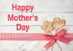 Happy Mothers Day - flower and heart with red ribbon on wooden background