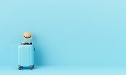 Blue suitcase with sun glasses, hat and camera on pastel blue background. travel concept. minimal style

