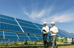 The solar farm(solar panel) with two engineers walk to check the operation of the system, Alternative energy to conserve the world's energy, Photovoltaic module idea for clean energy production.