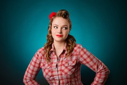 Closeup young pretty pinup girl red button shirt  looking aside  teal color background retro vintage 50's style. Human emotions body language