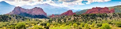 Beautiful view of Garden of the Gods in Colorado Springs. The Red Rock stone formations rise hundreds of feet above the desert floor. In the distance you can see Pikes Peak and the Rocky Mountains.