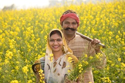 Rural Indian couple farming in agricultural field