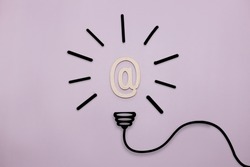 An idea symbol in the form of a drawn light bulb with an Internet sign on a purple background. Time to think and seek information