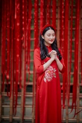 Ho Chi Minh City, Vietnam: Portrait of a brilliant Vietnamese girl in a red ao dai to welcome the Vietnamese traditional New Year