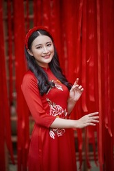 Ho Chi Minh City, Vietnam: Portrait of a brilliant Vietnamese girl in a red ao dai to welcome the Vietnamese traditional New Year