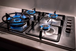 Gas cooktop burning gas stove with blue flame and lights on