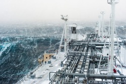 Big gas carrier sailing through an stormy arctic sea.