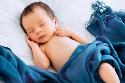 Close up portrait of a newborn baby sleeping in bed