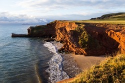 High angle view of red sandstone cliffs and Dunes-du-Sud beach seen during a sunny fall sunrise, Havre-aux-Maisons, Magdalen Islands, Quebec, Canada
