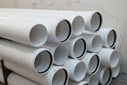 White pipes with rubber sealing rings. PVC tube pipe,Plastic pipe or polypropylene or polyethylene, stacked white round profile.Durable and anticorrosive properties of water pipes, drainage system