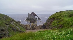 Bow Fiddle Rock is a natural sea arch near Portknockie in the north east of Scotland. The rock arch made of quartzite is so named because it resembles the tip of a violin bow.