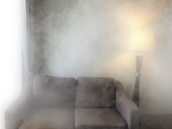 sofa and  lamp in smoke. Black and white in The house is mysterious and old.
