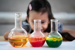 Unidentified 5 years old student is observe the water and oil separation for liquid density easy science experimental at home, homeschool, stem education, self learning for kid in family life.