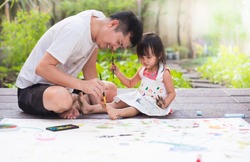 Asian father and daughter are playing by color painting together with fully happiness moment, concept of learning activity for kid in family lifestyle