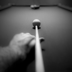 Point of view looking down pool stick aimed at cue ball. Focus is at end of stick and cue ball. Keep your eye on the ball. Focus on what matters.