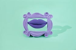 Big lips with purple lipstick in a retro purple frame on pastel green background. Surreal creative concept for Valentines banner. Artistic design for engagement party invitation 