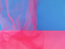An abstract background in blue, magenta and pink with magenta tulle fabric. Minimal design for announcement, ad, invitation or banner. Colorful trendy wallpaper or backdrop.  Copy space.