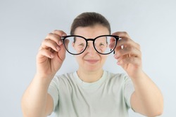 young woman rubs tired eyes from glasses, poor eyesight, vision problems.