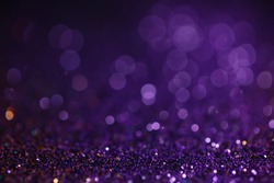 Decoration bokeh glitters background, abstract glowing backdrop with circles,modern design wallpaper with sparkling glimmers. Black, purple and golden backdrop glittering sparks with glow effect