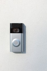 Ring Intercom outdoors  on white plastered wall with call and camera, copy space. 
