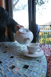 hot tea ,kettle and tea cup or tea pot or pouring tea