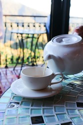 hot tea ,kettle and tea cup or tea pot or pouring tea