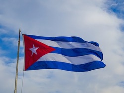 Big cuban flag with a cloudy sky on the background (Havana, Cuba).