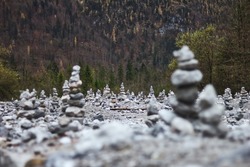 Field with stone towers near forest

Many piles of rocks located in field near mountain slope and forest on autumn day in Bavarian Alps
