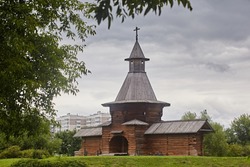 Beautiful wooden fortress made of logs, tower with entrance wolves on the background of the summer landscape and gray sky. Traditional old architecture of the north of the Middle Ages.