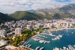 Budva. Montenegro. Aerial view of the city, port, beach and mountains. Budva is surrounded by mountains. Budva with red tile roofs, high-rise buildings, residential areas. Adriatic Sea View from above