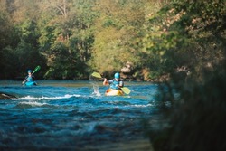 Whitewater kayaker paddling on the waters of river. Adrenaline seekers and nature lovers.