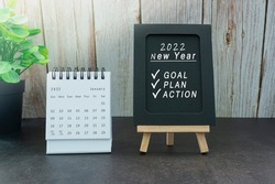 January 2022 white calendar with text on black notepad - New year concept