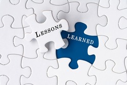 Lessons learned text on Jigsaw Puzzle over dark blue background.