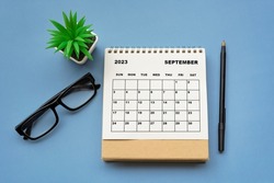 September 2023 desk calendar on blue background. Directly above. Flat lay. Copy space.