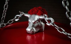 figurine of a bull's head with transportation hooks on horns and a metal chain