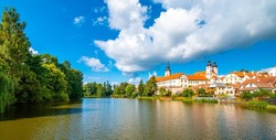 Panorama view of Telc city, Czech Republic. Historical castle above the lake. UNESCO heritage. Summer day, blue sky with clouds.