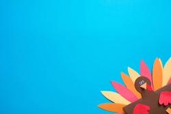 blue background with copy space. paper craft for kids. DIY Turkey made for thanksgiving day. create art for children.
