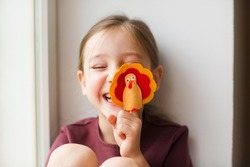 craft for kids. DIY felt Turkey for thanksgiving day. create art for children. girl playing with finger toy.