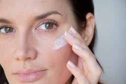 
woman applies wrinkle cream on lower eyelid