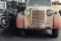 Many rusty abandoned forgotten antique oldtimer old car and motorcycles at junkyard factory storage warehouse indoors. Classic vintage retro vehicles detail garage workshop restore renovation station