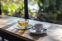A cup of coffee and tea on wooden table