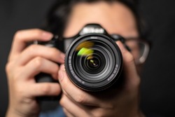 photographer take pictures Snapshot with camera. man hand holding with camera looking through lens.Concept for photographing articles Professionally.