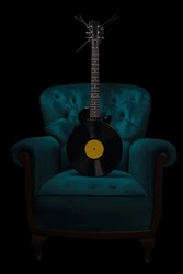 Electric guitar and armchair vinyl record. Recording studio concept. Black background.