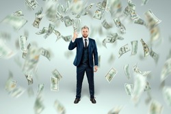 A man in a business suit tosses dollars up, it rains money. Business concept, bookmaker, sports betting, investment, passive income