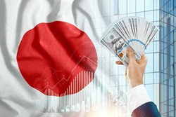 Money in a man's hand against the background of the flag of Japan. Japanese income. The financial condition of the inhabitants of Japan, taxes, loans, mortgages. Government debt of Japan